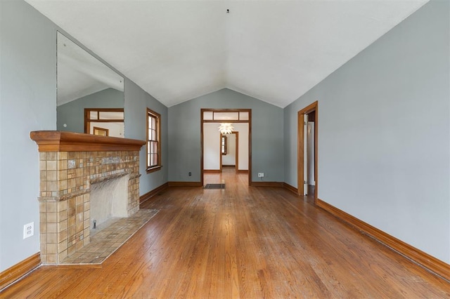 unfurnished living room with hardwood / wood-style flooring and vaulted ceiling