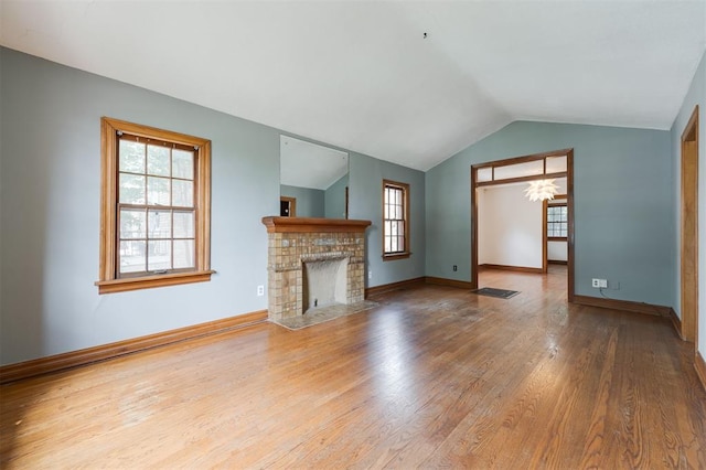 unfurnished living room featuring hardwood / wood-style floors and lofted ceiling