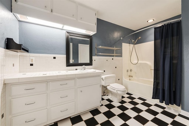 full bathroom with shower / bath combo, toilet, tile walls, and vanity