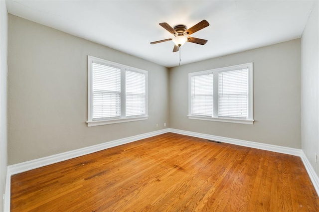 spare room featuring a wealth of natural light, ceiling fan, and light wood-type flooring