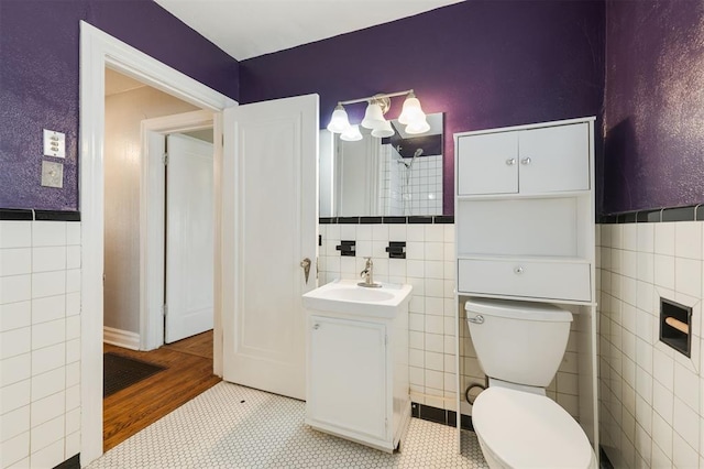 bathroom with tile patterned flooring, toilet, and tile walls