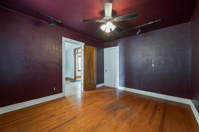 empty room with ceiling fan and hardwood / wood-style flooring