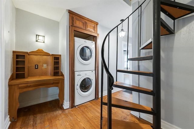 laundry area with light wood-type flooring and stacked washer and dryer