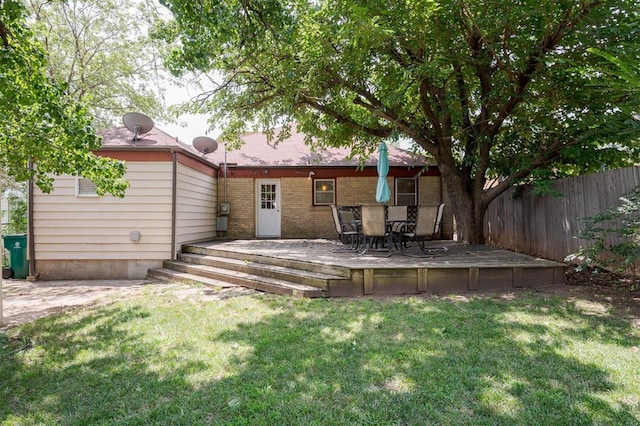 rear view of property with a lawn and a deck