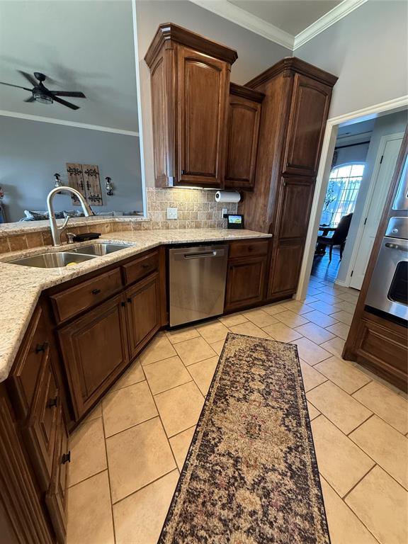 kitchen with stainless steel dishwasher, ceiling fan, light tile patterned flooring, and sink