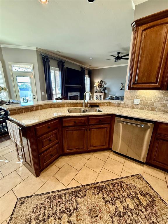 kitchen featuring dishwasher, crown molding, sink, ceiling fan, and kitchen peninsula