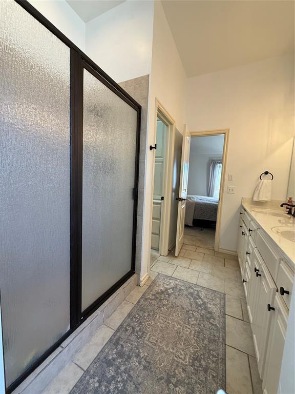 bathroom with tile patterned flooring, vanity, and a shower with shower door