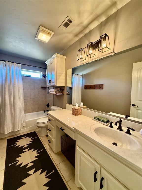 full bathroom with tile patterned flooring, vanity, toilet, and shower / tub combo