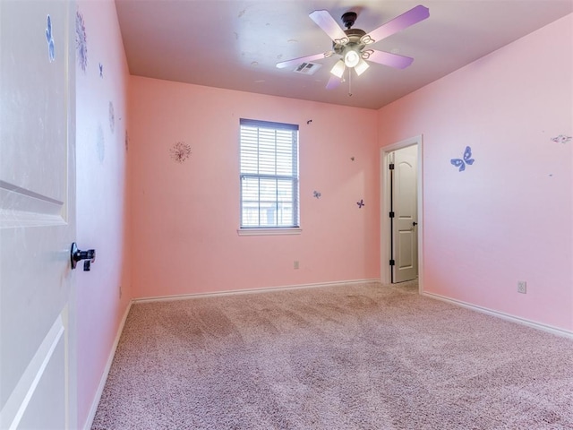 spare room with ceiling fan and carpet