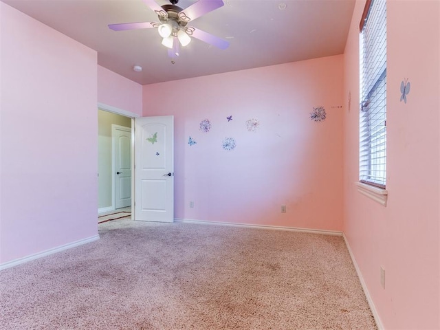 carpeted spare room with ceiling fan