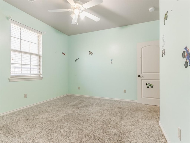 unfurnished room with ceiling fan and carpet