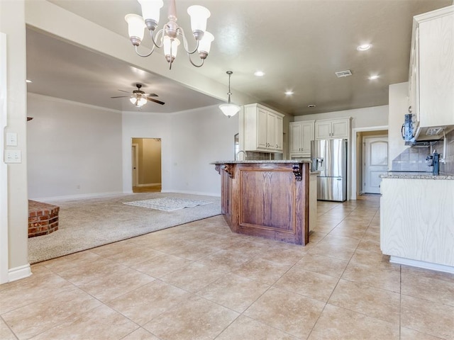 kitchen featuring ceiling fan with notable chandelier, appliances with stainless steel finishes, white cabinetry, light stone countertops, and decorative light fixtures