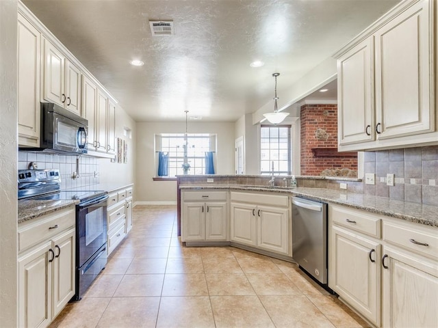 kitchen with pendant lighting, sink, stainless steel dishwasher, light tile patterned floors, and black electric range