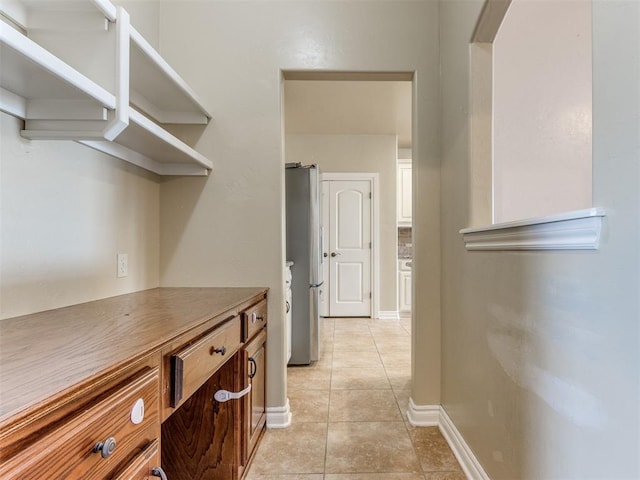 kitchen with stainless steel fridge and light tile patterned floors