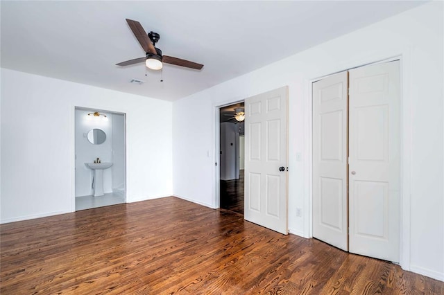 interior space featuring dark wood-type flooring, sink, ensuite bath, ceiling fan, and a closet