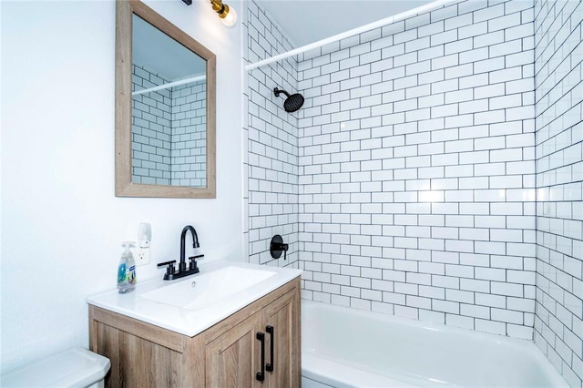 full bathroom with tiled shower / bath combo, toilet, and vanity