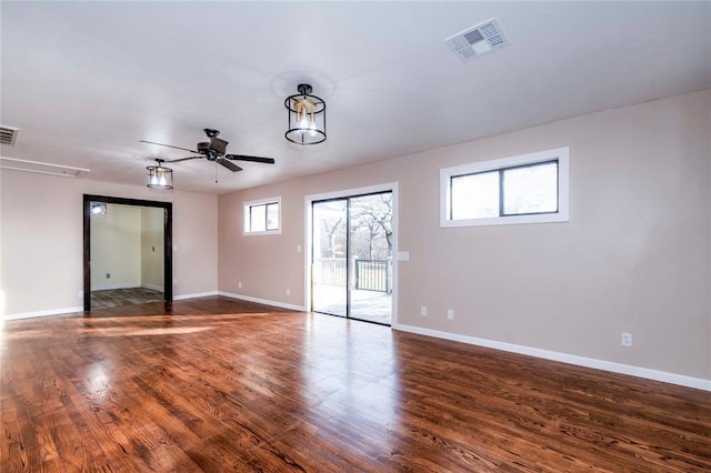 spare room featuring a wealth of natural light, ceiling fan, and dark hardwood / wood-style floors