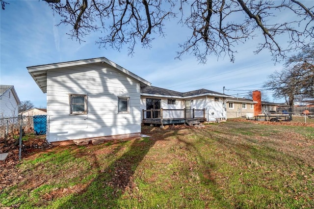 back of property with a lawn and a wooden deck