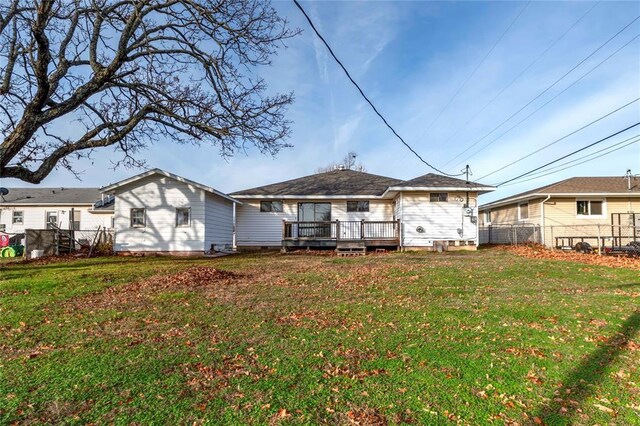 back of property with a lawn and a deck