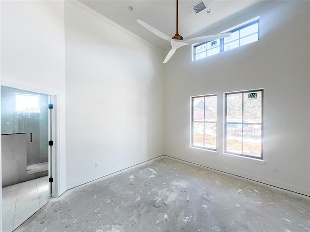 unfurnished room featuring a towering ceiling, baseboards, and visible vents