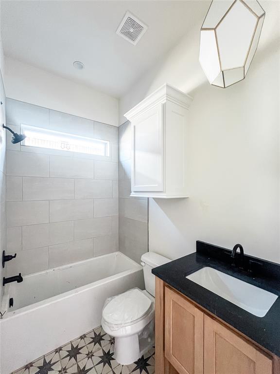 full bathroom featuring toilet, shower / bathtub combination, vanity, and visible vents