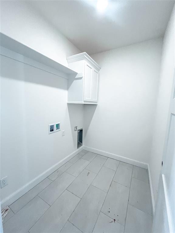 clothes washing area featuring baseboards, washer hookup, cabinet space, and electric dryer hookup