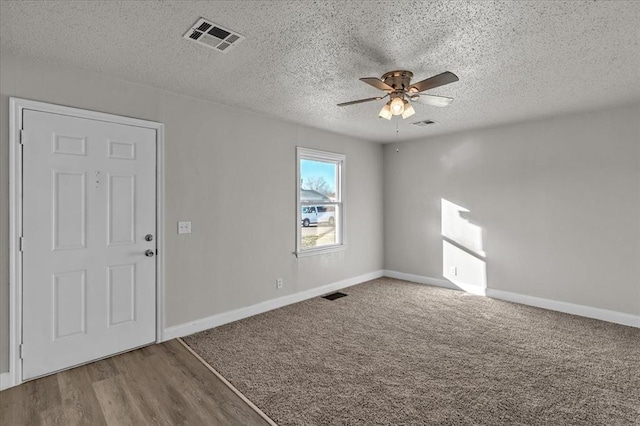 unfurnished room featuring hardwood / wood-style floors, ceiling fan, and a textured ceiling