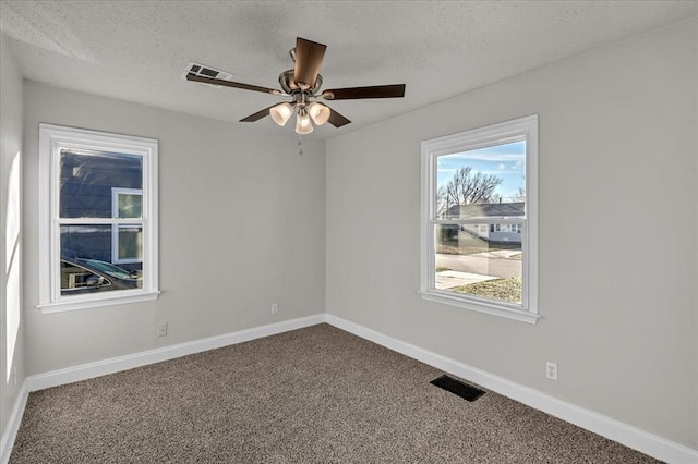 unfurnished room with ceiling fan, carpet, and a textured ceiling