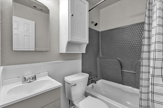 full bathroom featuring vanity, wooden walls, shower / bathtub combination with curtain, and toilet