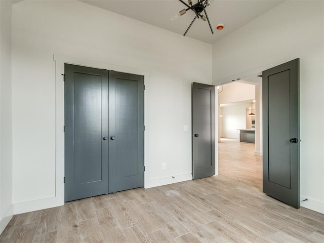 1203 Jaden Blvd, Tuttle, OK 73089 - unfurnished bedroom featuring light wood-style flooring, a closet, and baseboards