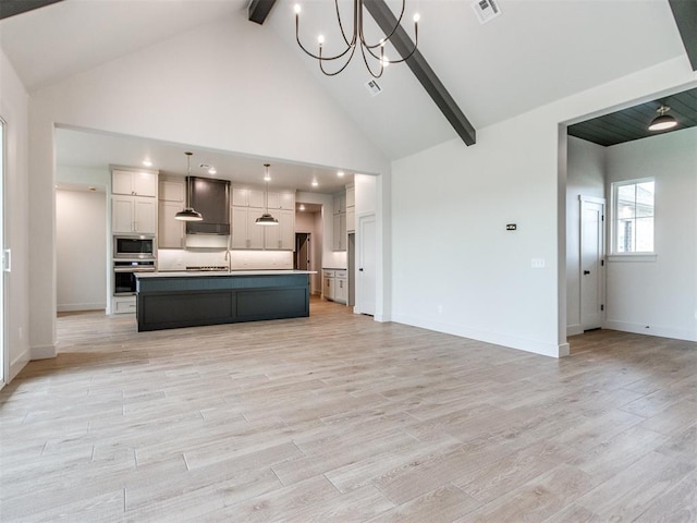 1203 Jaden Blvd, Tuttle, OK 73089 - kitchen featuring appliances with stainless steel finishes, open floor plan, a chandelier, beam ceiling, and high vaulted ceiling