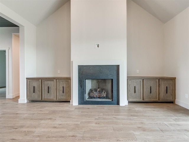 1203 Jaden Blvd, Tuttle, OK 73089 - unfurnished living room featuring light wood-type flooring, high vaulted ceiling, a fireplace, and baseboards