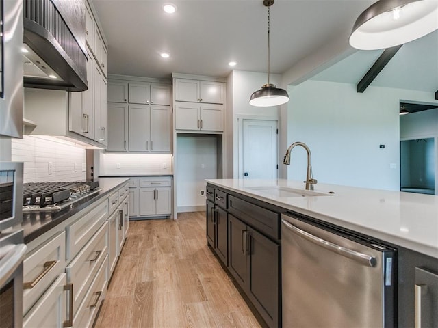 1203 Jaden Blvd, Tuttle, OK 73089 - kitchen with stainless steel dishwasher, a sink, ventilation hood, light wood-style flooring, and decorative light fixtures