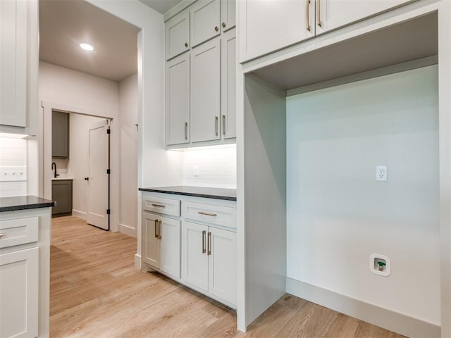 1203 Jaden Blvd, Tuttle, OK 73089 - kitchen with light wood-style flooring, baseboards, recessed lighting, and dark stone counters