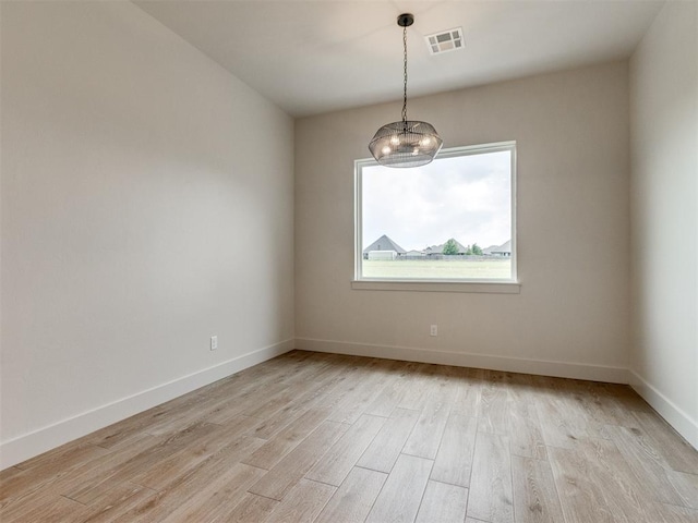 1203 Jaden Blvd, Tuttle, OK 73089 - unfurnished room featuring light wood-type flooring, a chandelier, and baseboards