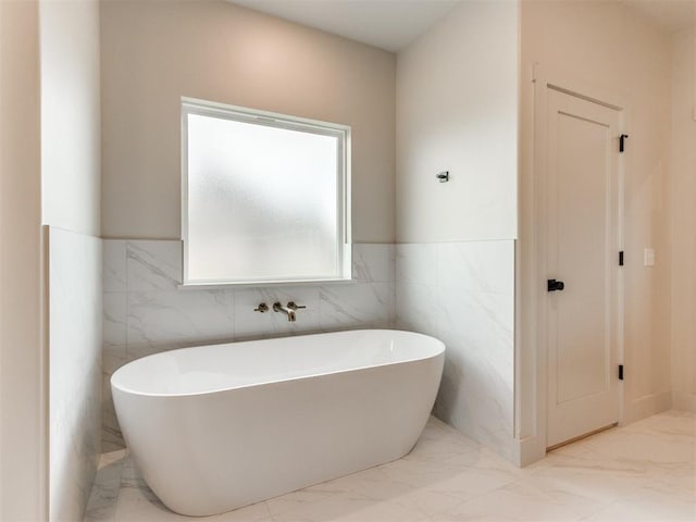 1203 Jaden Blvd, Tuttle, OK 73089 - full bathroom with marble finish floors, a freestanding tub, wainscoting, and tile walls