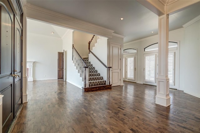 foyer with decorative columns, crown molding, and dark wood-type flooring