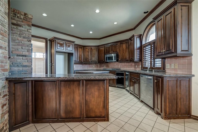 kitchen featuring dark stone countertops, decorative backsplash, dark brown cabinetry, and stainless steel appliances