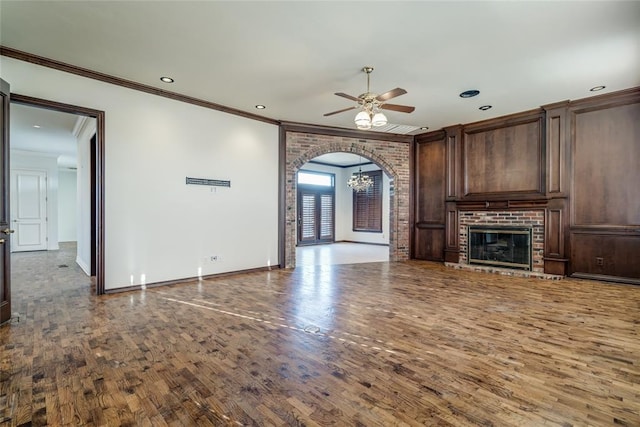 unfurnished living room featuring ceiling fan, crown molding, wood-type flooring, and a fireplace