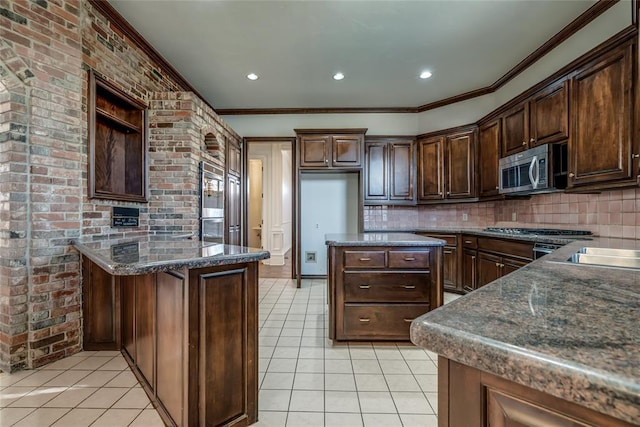 kitchen with brick wall, dark stone countertops, decorative backsplash, dark brown cabinets, and light tile patterned floors