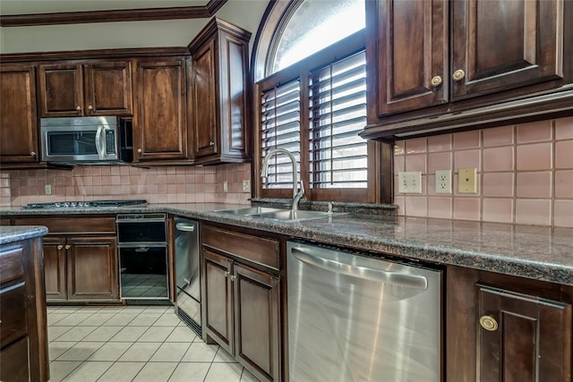 kitchen with sink, decorative backsplash, dark brown cabinets, light tile patterned floors, and appliances with stainless steel finishes