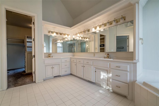 bathroom with a bathing tub, vanity, tile patterned floors, and lofted ceiling