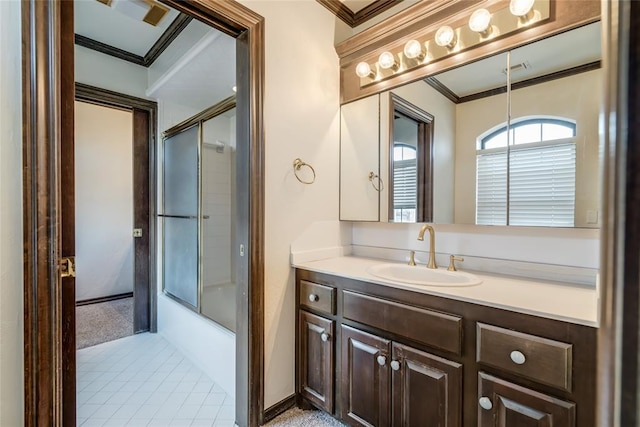 bathroom featuring vanity, ornamental molding, and bath / shower combo with glass door