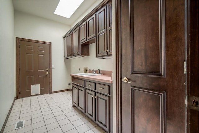 washroom featuring cabinets, hookup for a washing machine, hookup for an electric dryer, a skylight, and sink