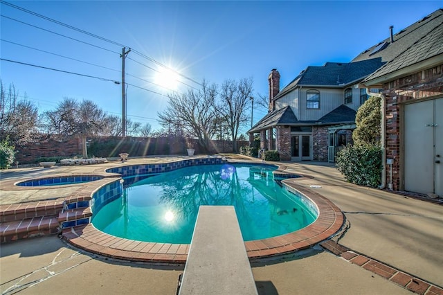 view of pool featuring an in ground hot tub, french doors, a patio, and a diving board