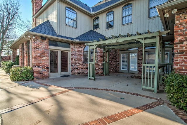 rear view of house with a pergola and a patio