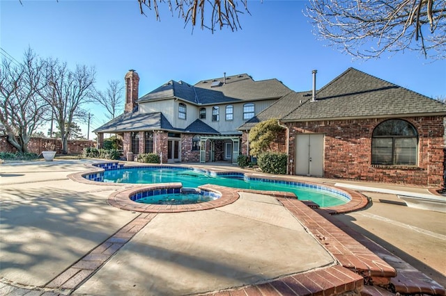 view of swimming pool featuring an in ground hot tub and a patio