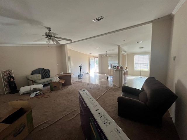 living room with ceiling fan, ornamental molding, and light carpet