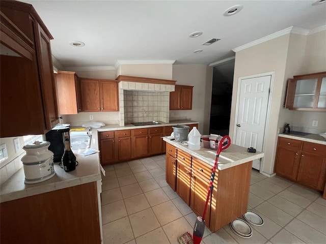 kitchen featuring light tile patterned floors, a center island, tasteful backsplash, and crown molding