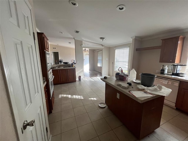 kitchen featuring light tile patterned floors, white appliances, and crown molding